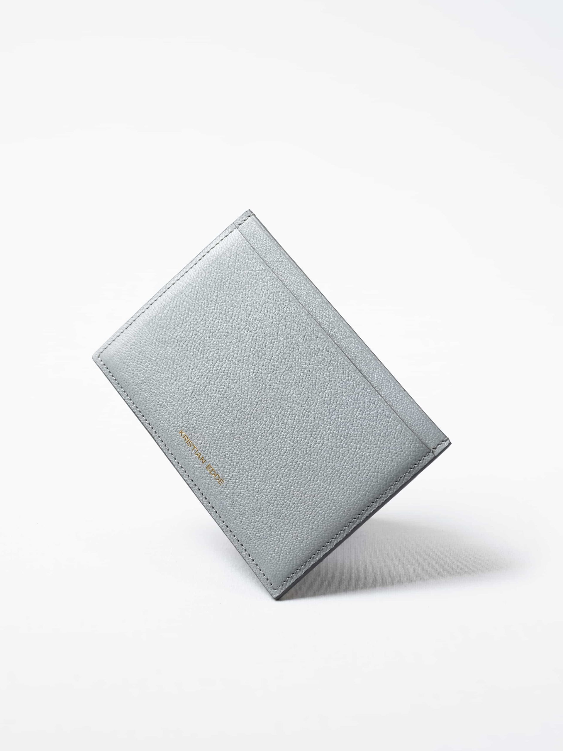 Himalayan gray Aurora travel wallet in fish leather with golden logo. Handcrafted in Stockholm, this luxury accessory elevates passports, cards, and travel style
