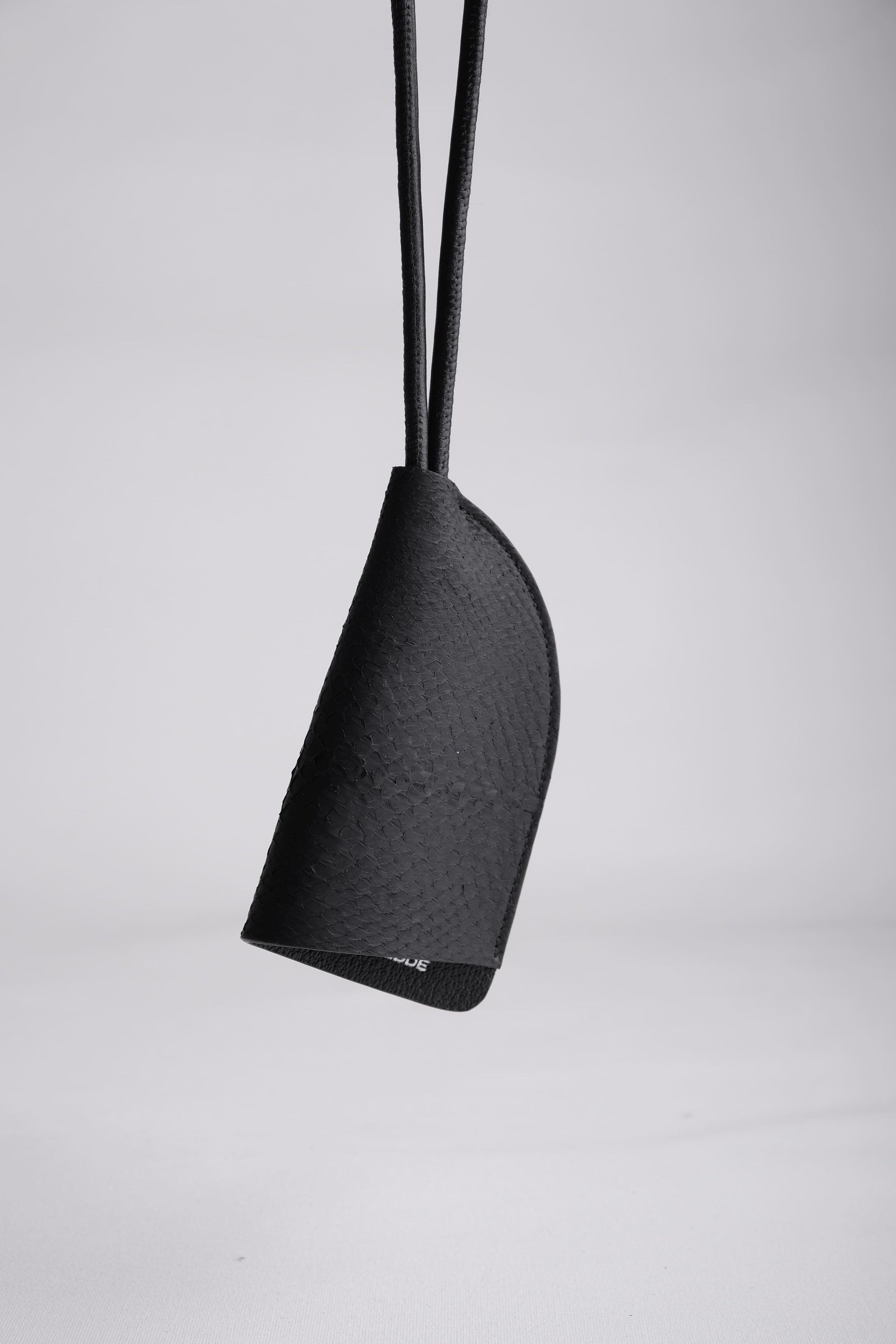 Close-up detail of black salmon leather texture on Fjord round neck keychain