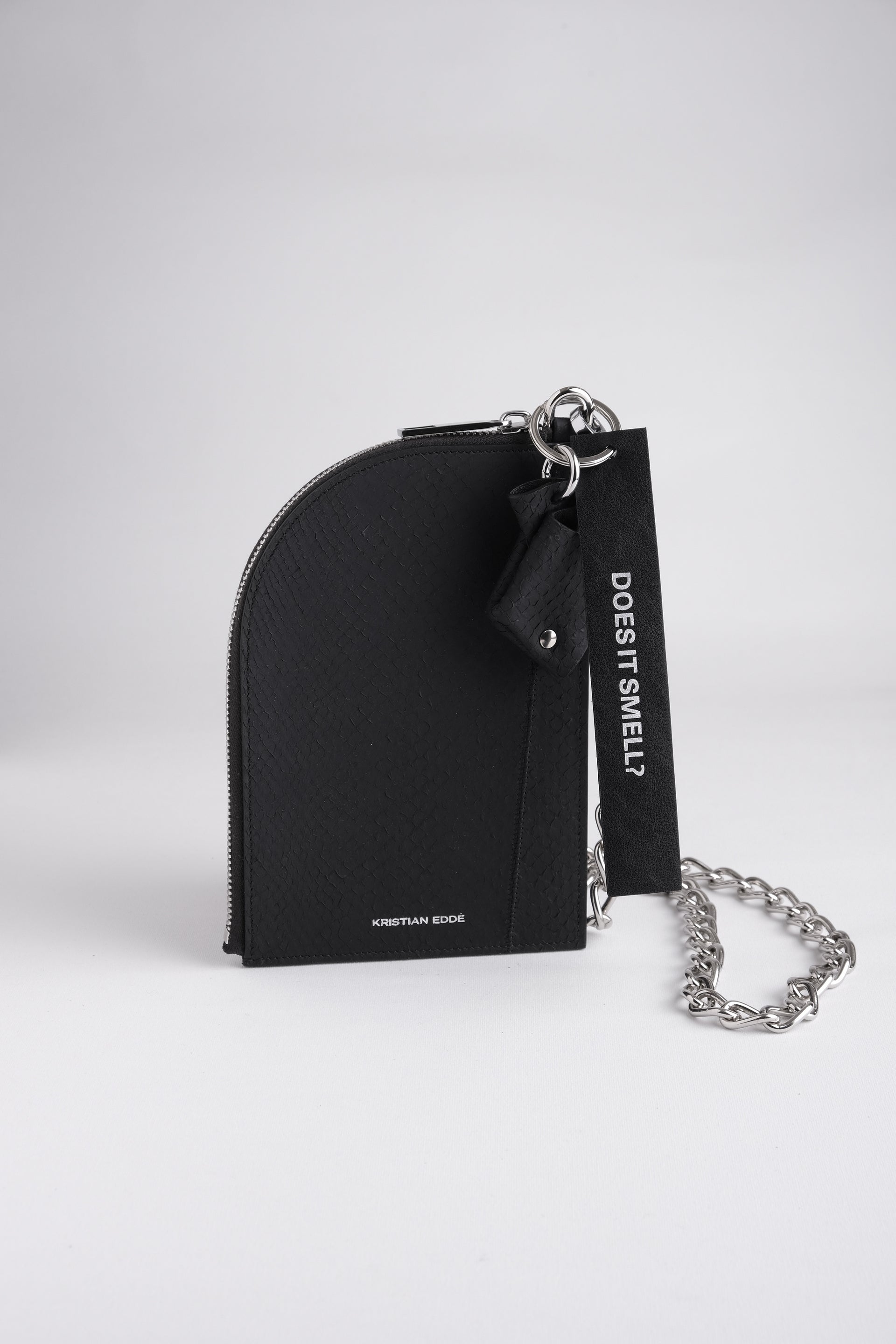 Nord zipper pouch on chain in arctic black salmon leather with a fish charm and key ring, front view on white background