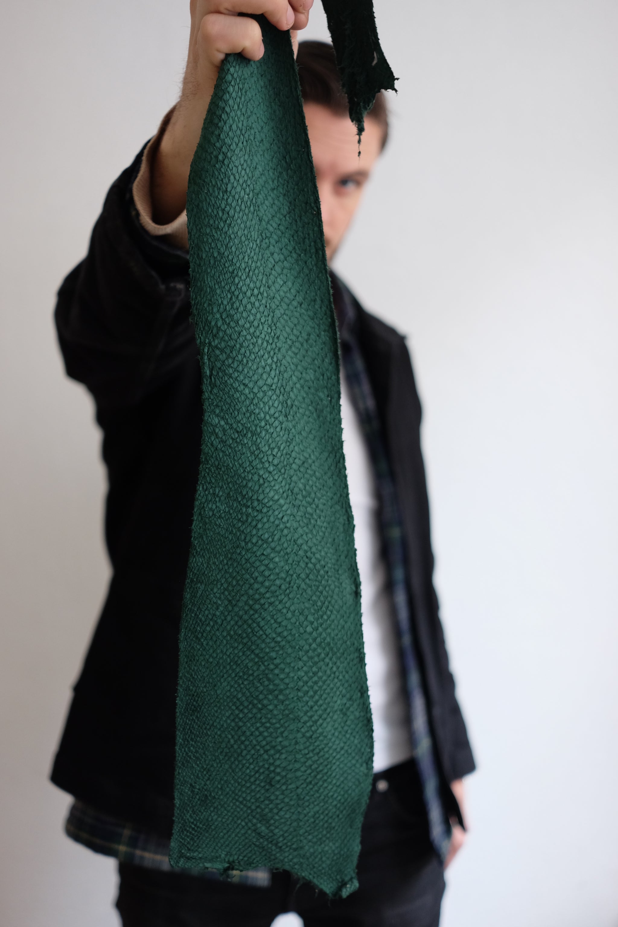 Kristian Edde holding a piece of salmon leather up close, highlighting the texture and pattern of the fish skin.