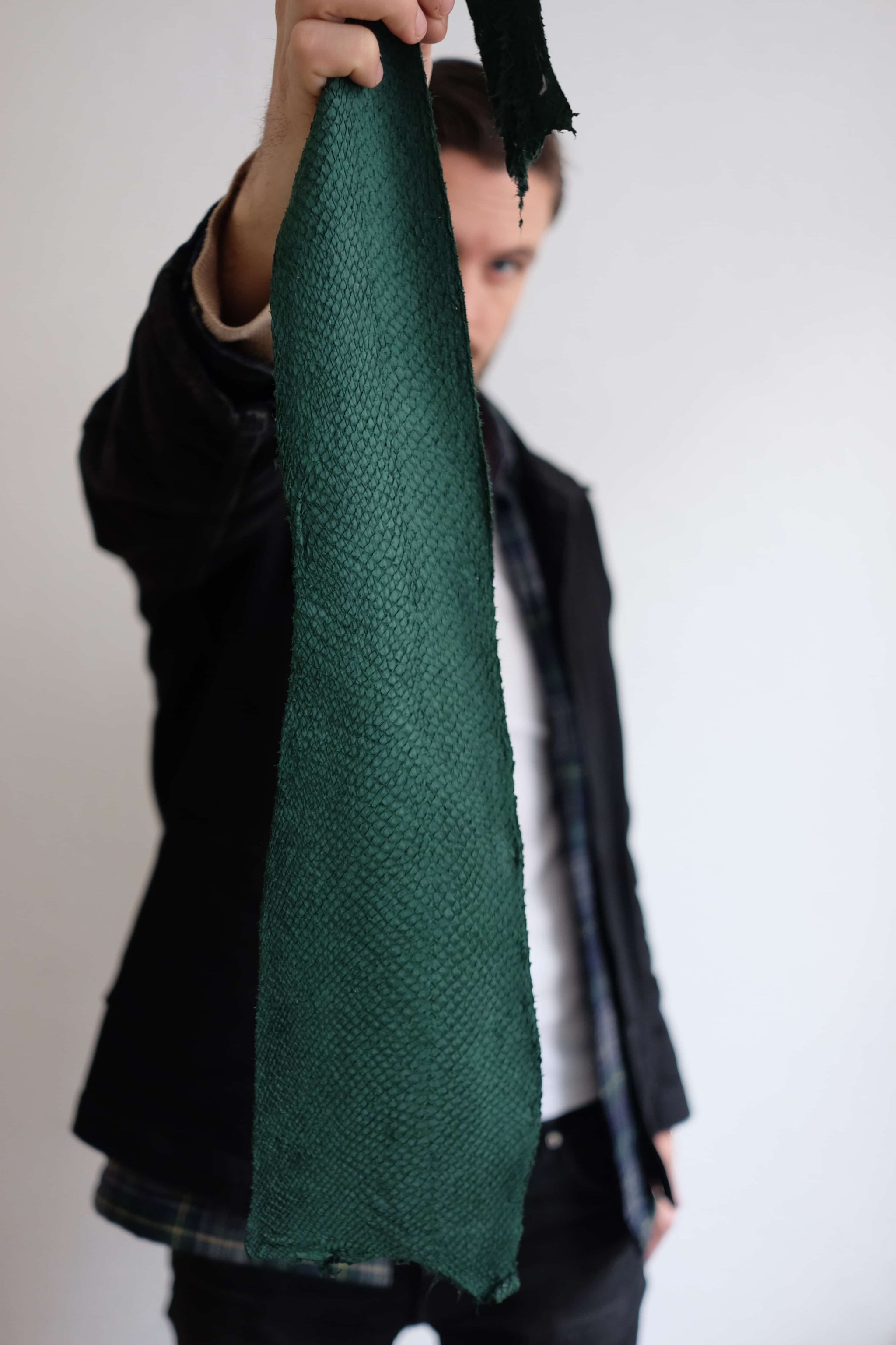 Kristian Edde holding a close-up piece of salmon leather, showcasing the natural texture and pattern of sustainable fish skin