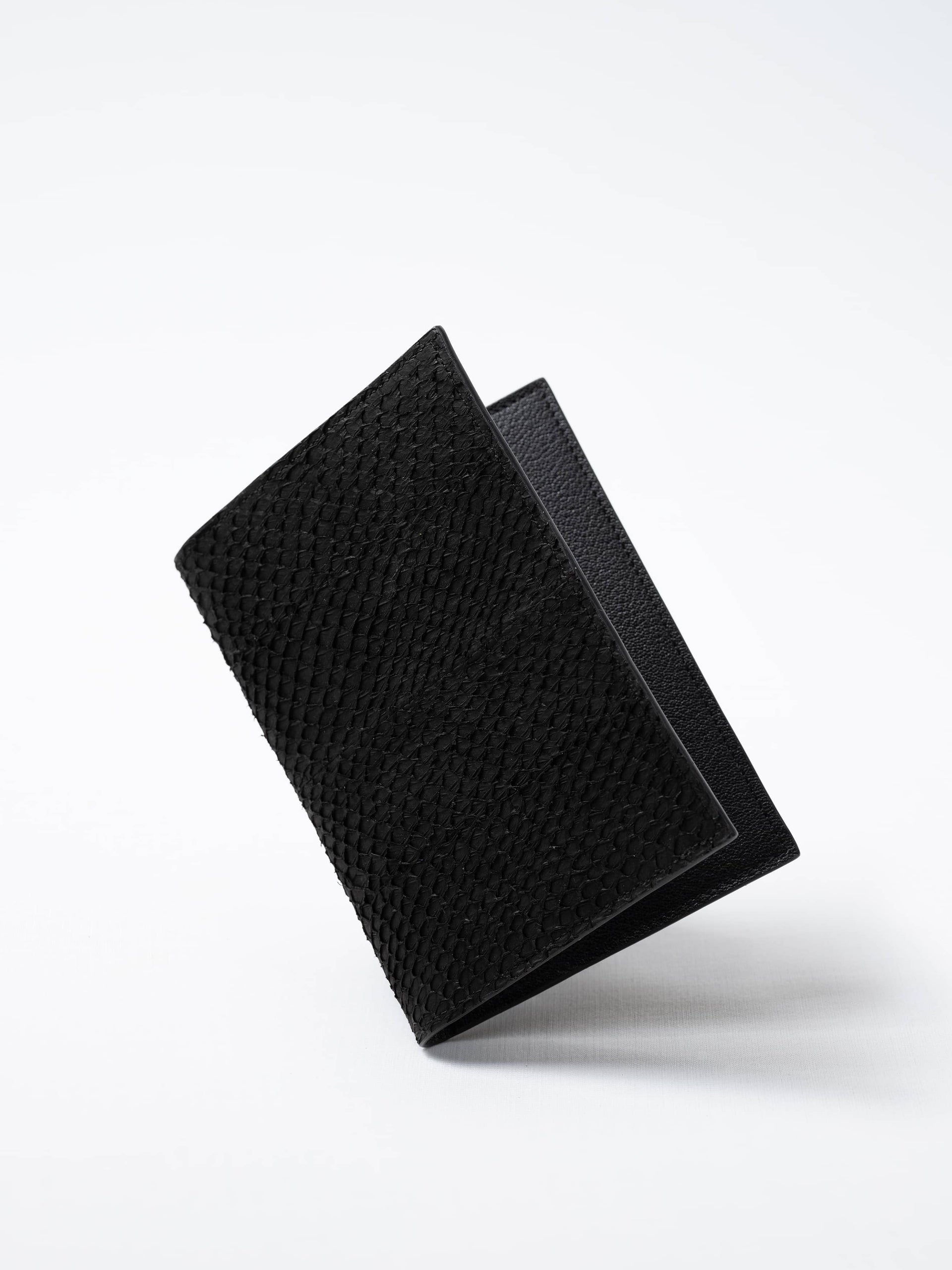 Vega luxury travel wallet in black fish leather, closed view highlighting the textured fish leather exterior, handcrafted in Sweden by Kristian Eddé
