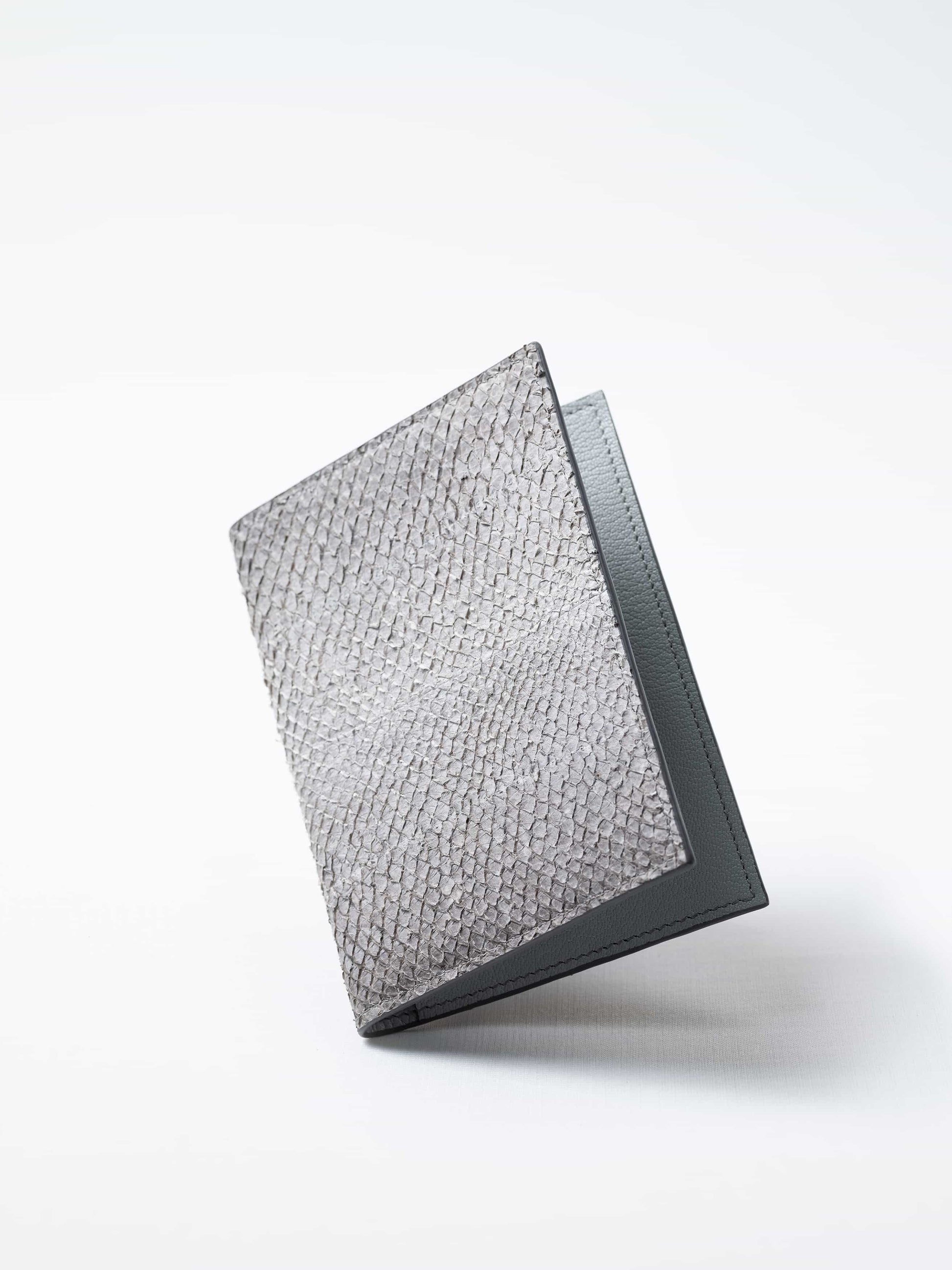 Vega luxury travel wallet in himalayan gray fish leather, closed view highlighting the textured fish leather exterior, handcrafted  in Sweden by Kristian Eddé