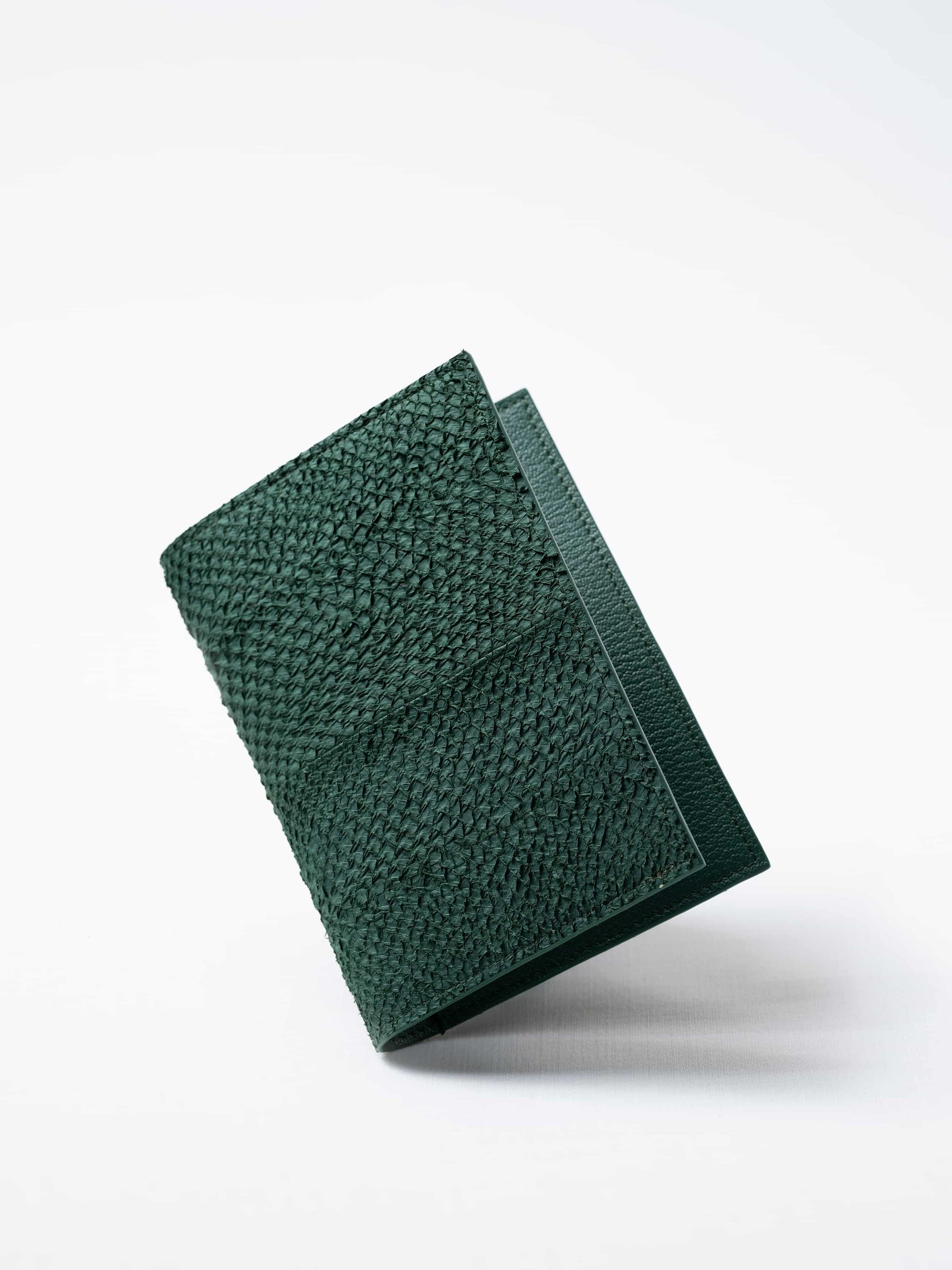 Vega luxury travel wallet in kelp green salmon leather, closed view highlighting the textured fish leather exterior, handcrafted  in Sweden by Kristian Eddé