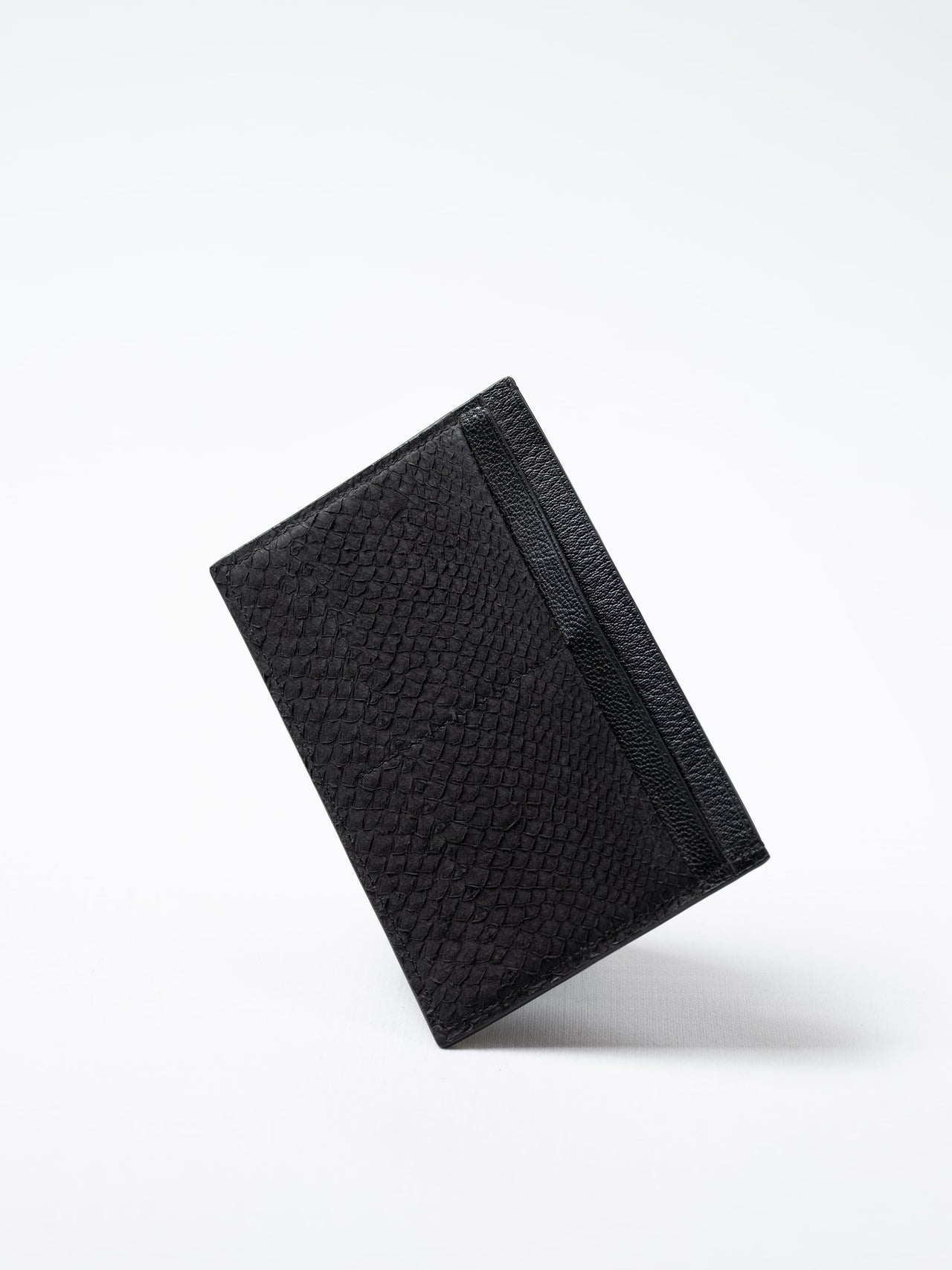 Discover the black Aurora travel wallet, handcrafted in sustainable salmon leather. A luxury accessory designed for passports, cards, and modern journeys 