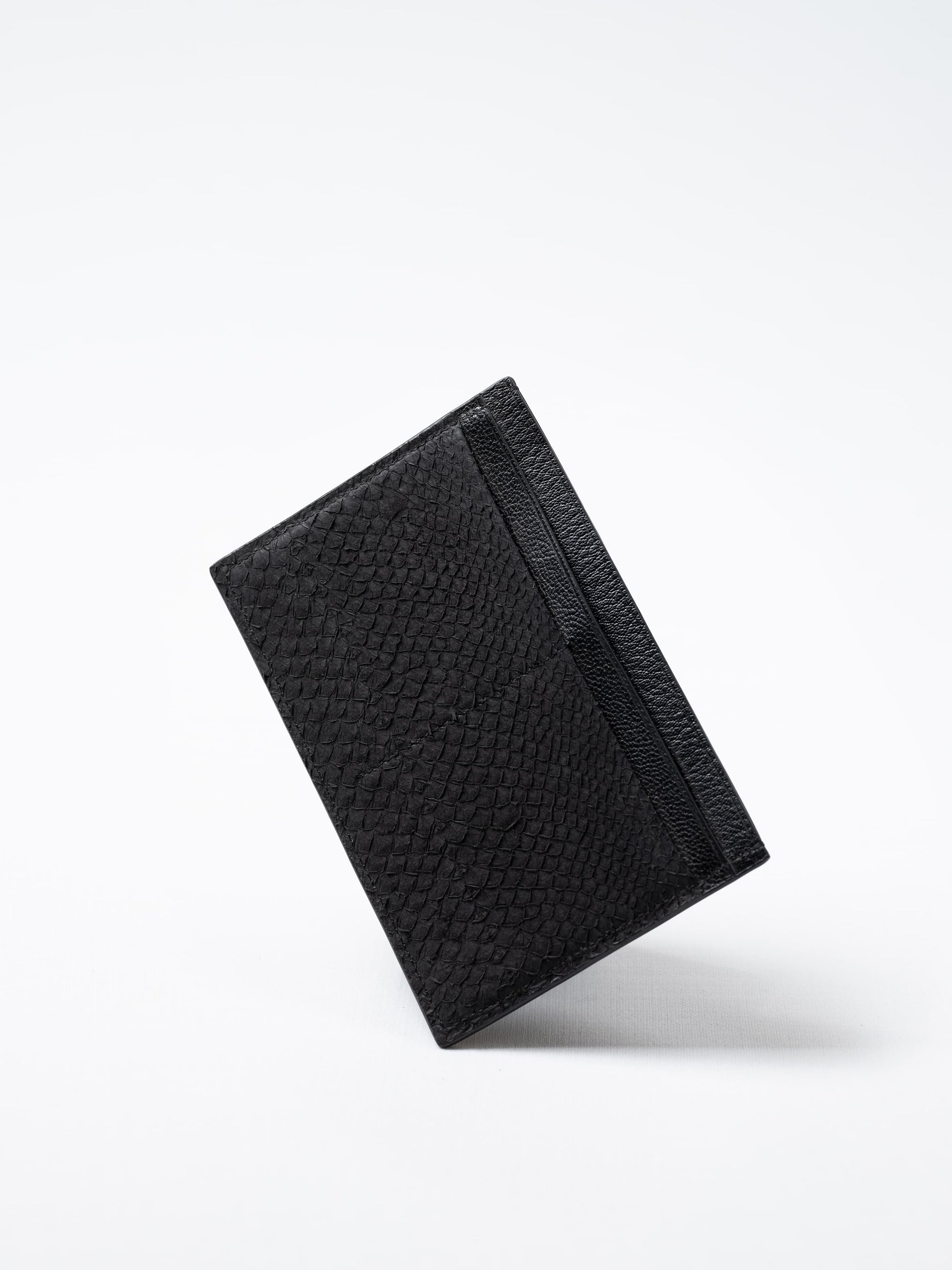 Discover the black Aurora travel wallet, handcrafted in sustainable salmon leather. A luxury accessory designed for passports, cards, and modern journeys
