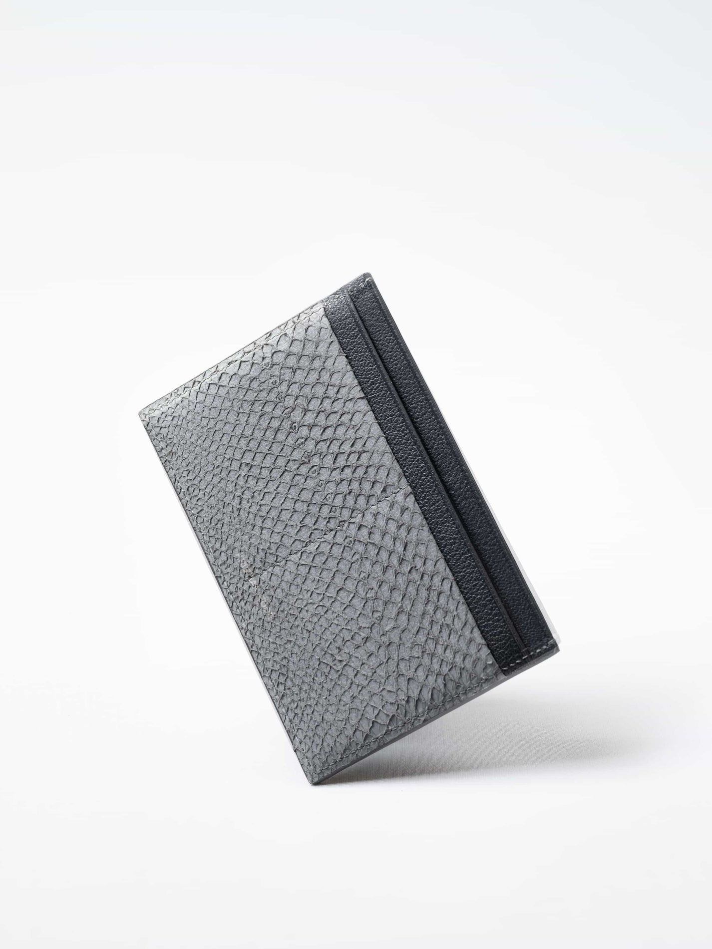 Discover the gray Aurora travel wallet, handcrafted in sustainable salmon leather. A luxury accessory designed for passports, cards, and modern journeys