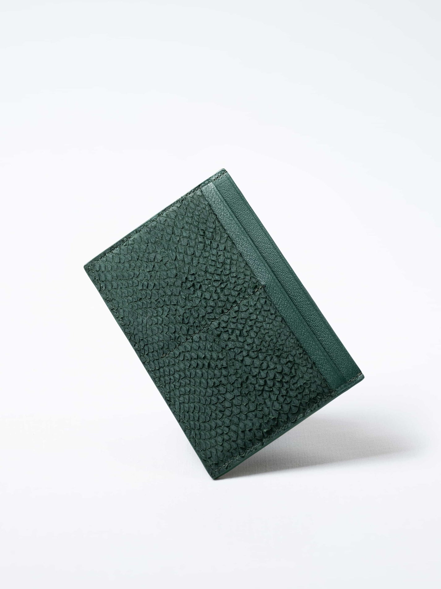 Discover the green Aurora travel wallet, handcrafted in sustainable salmon leather. A luxury accessory designed for passports, cards, and modern journeys