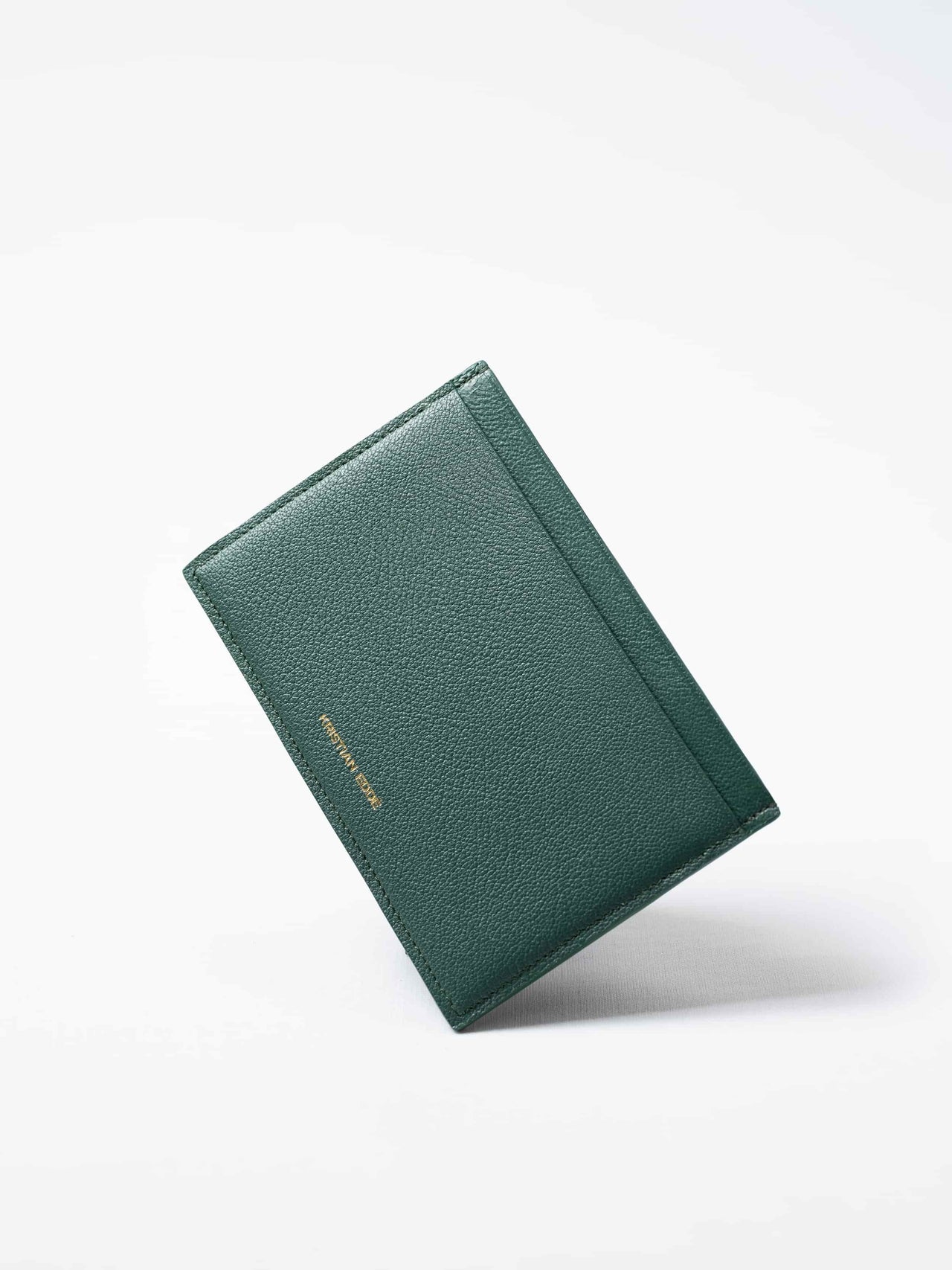Green Aurora travel wallet in fish leather with golden logo. Handcrafted in Stockholm, this luxury accessory elevates passports, cards, and travel style