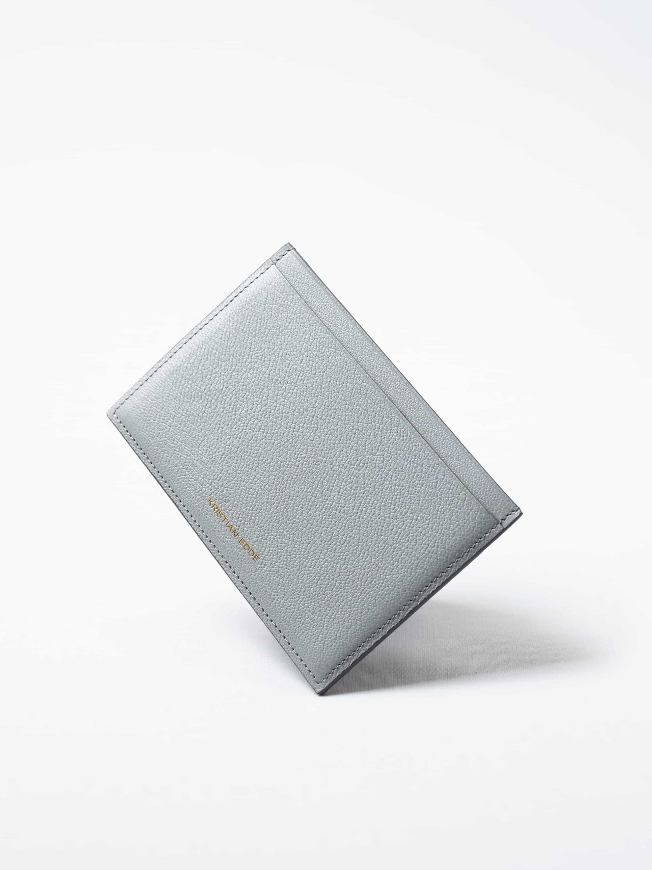 Himalayan gray Aurora travel wallet in fish leather with golden logo. Handcrafted in Stockholm, this luxury accessory elevates passports, cards, and travel style
