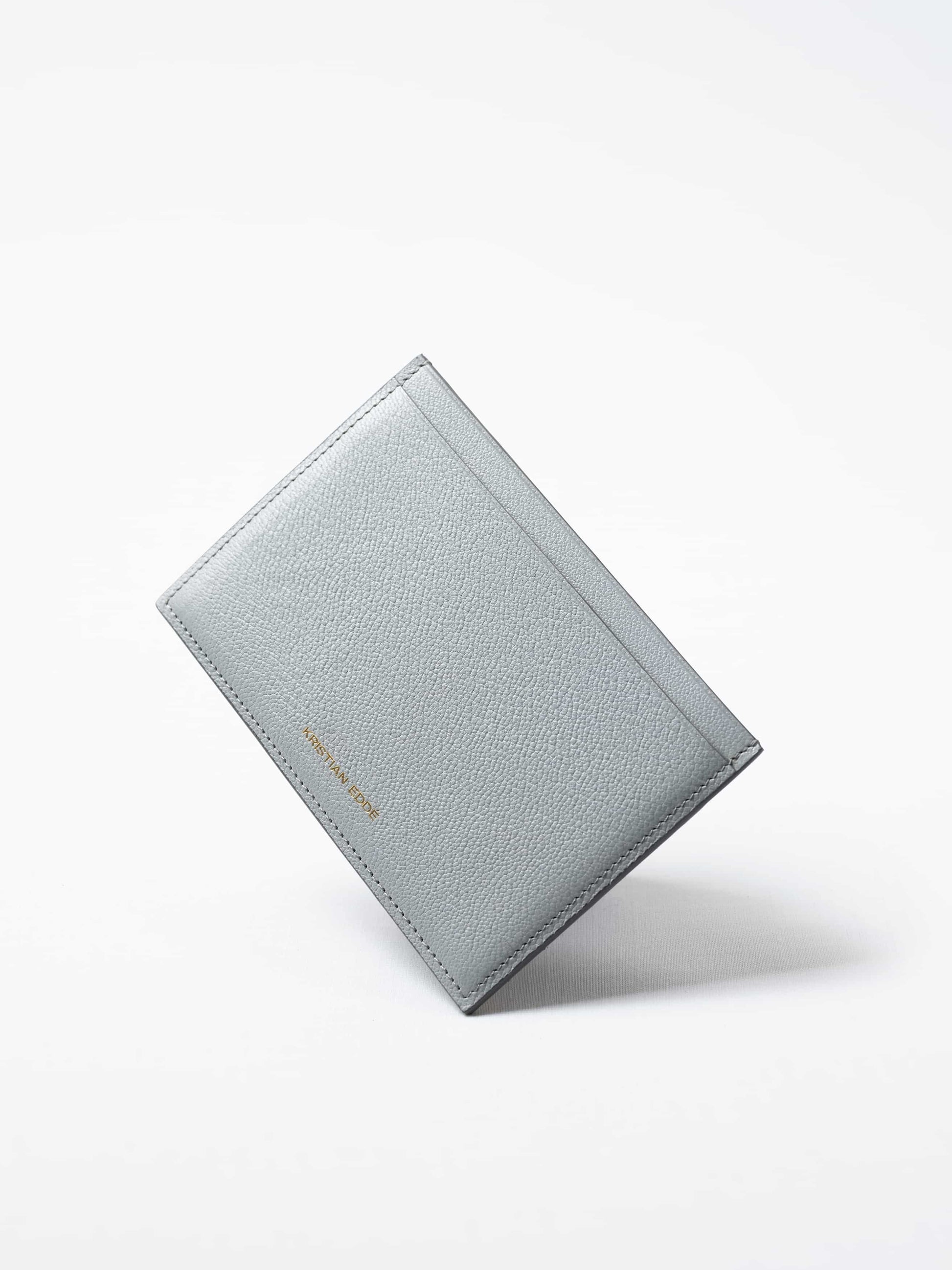 Himalayan gray Aurora travel wallet in fish leather with golden logo. Handcrafted in Stockholm, this luxury accessory elevates passports, cards, and travel style