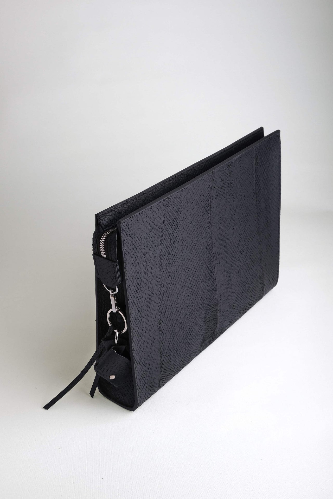 Angled top view of the Baltic Clutch showcasing its sculptural silhouette and wave-like salmon leather texture.