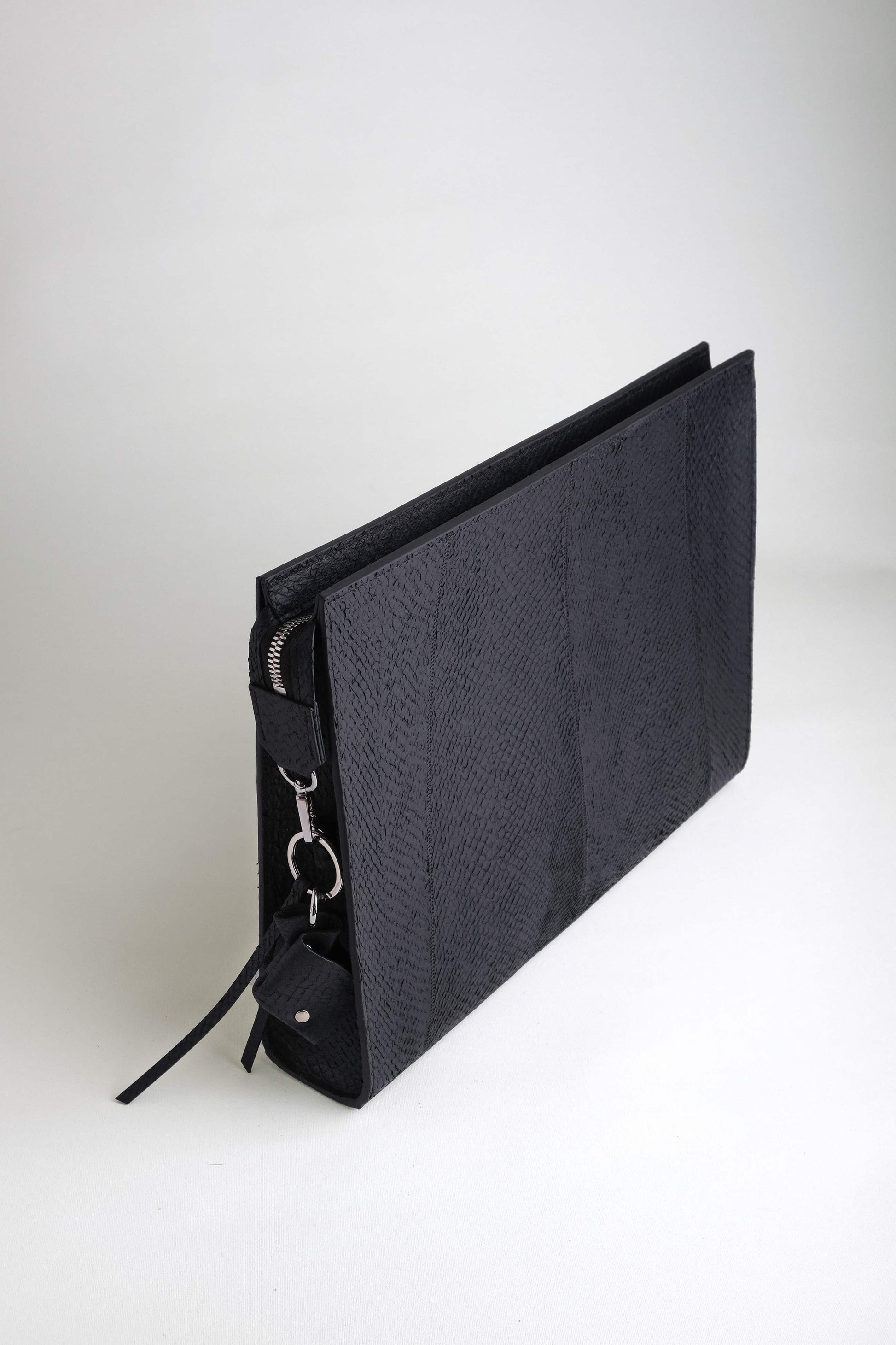 Angled top view of the Baltic Clutch showcasing its sculptural silhouette and wave-like salmon leather texture.