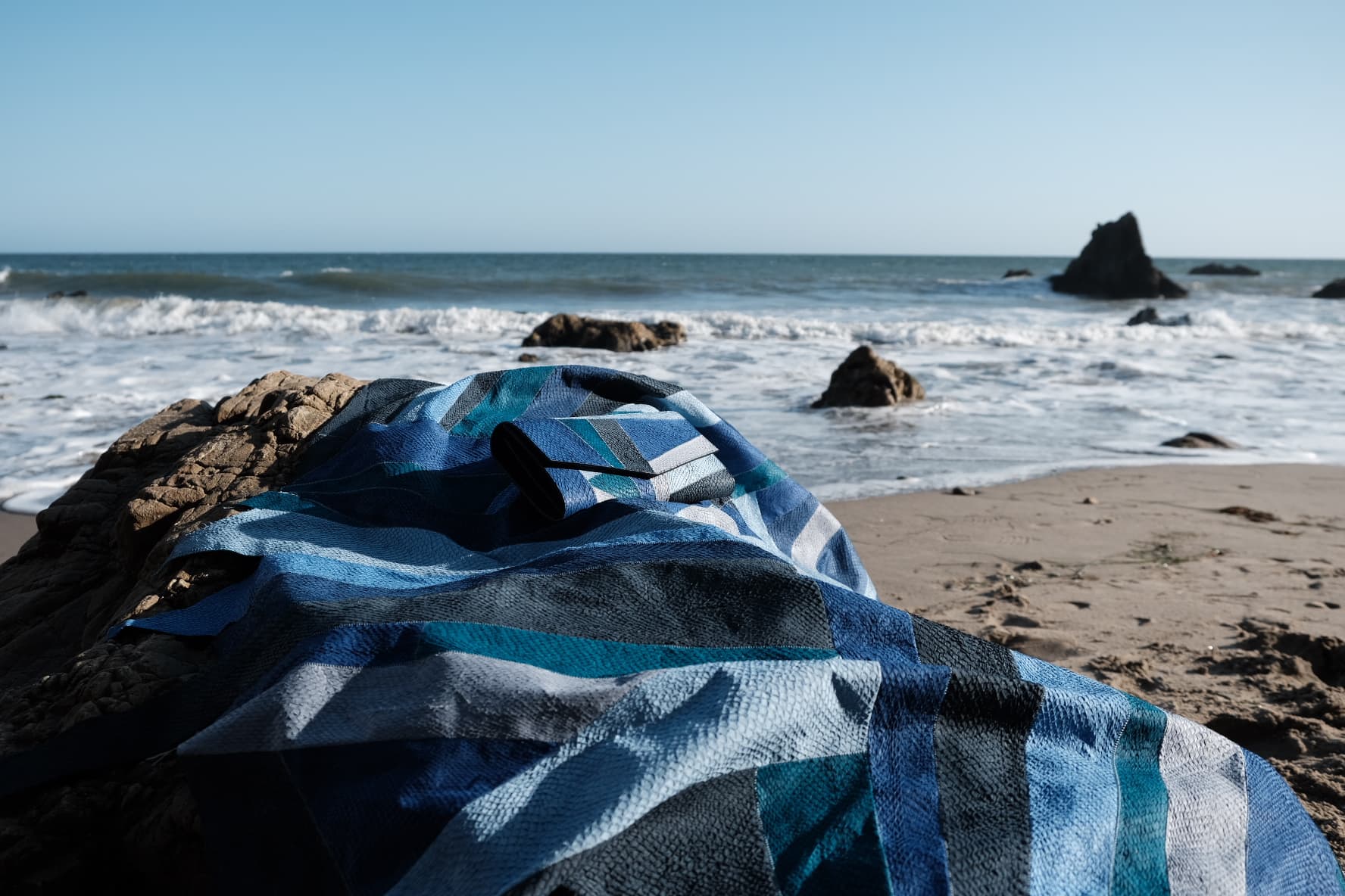 Handcrafted California Canvas material made from patchwork of 40 fish leather pieces, forming a unique textured fish leather fabric used for luxury accessories by Kristian Eddé