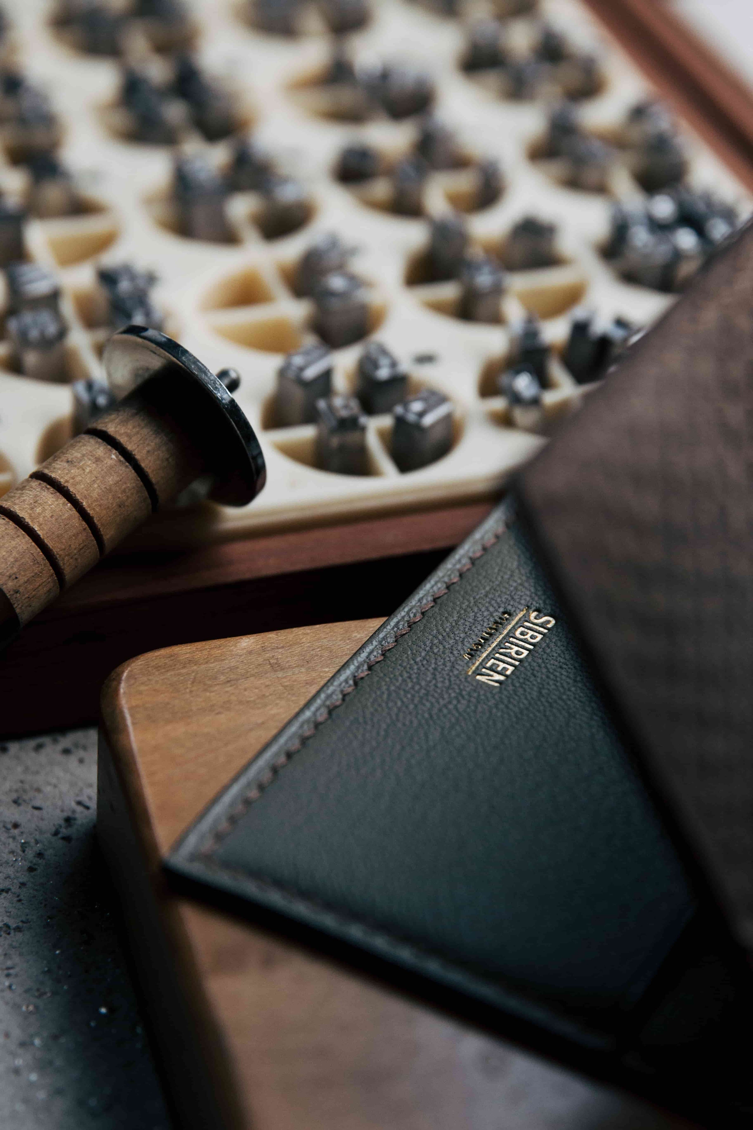 Kristian Eddé leather product displayed alongside a News Gothic font used for precise embossing and monogramming.