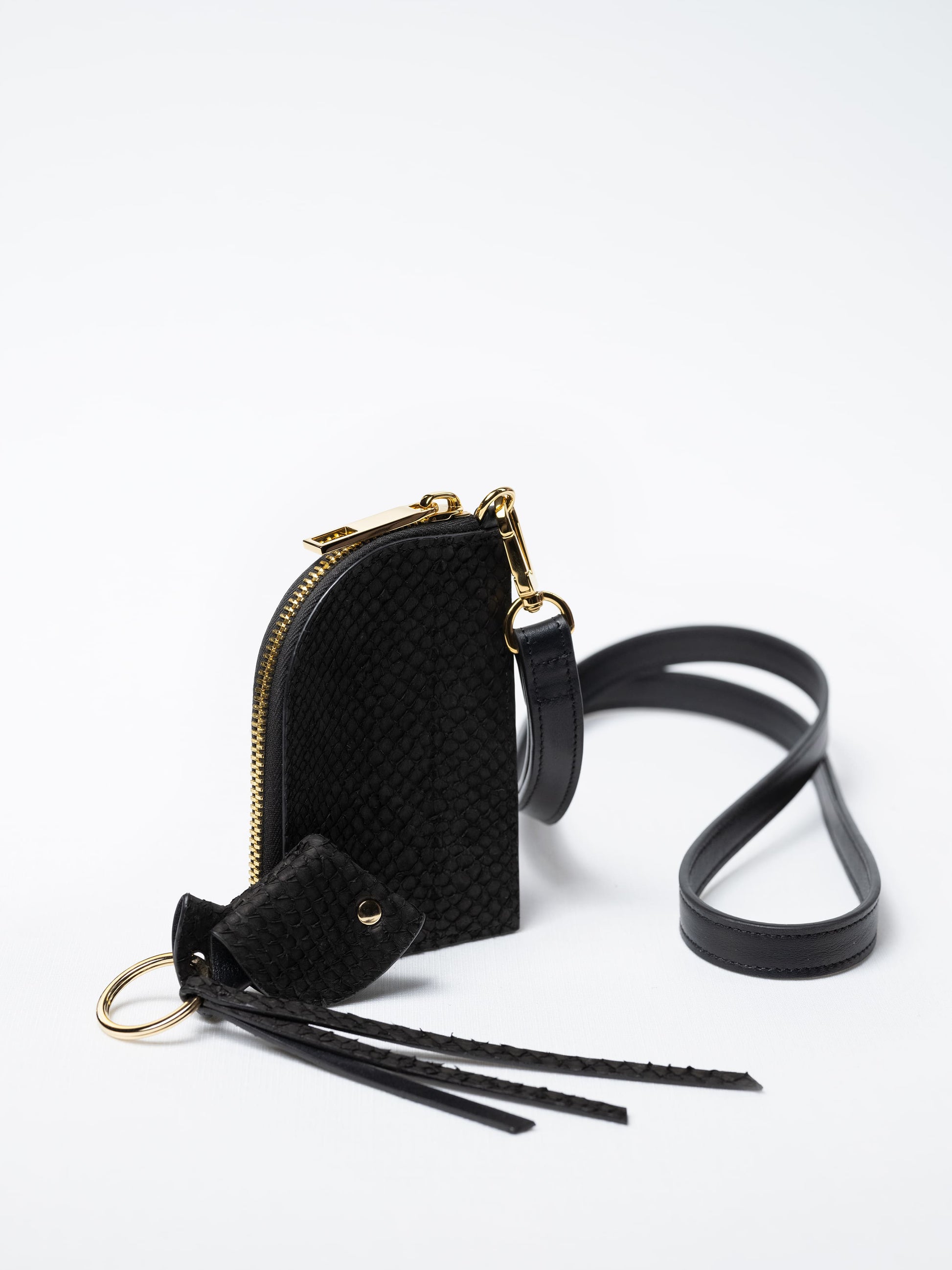Salma zipper wallet on strap in black fish leather with gold zipper and key charm – sustainable luxury by Kristian Eddé