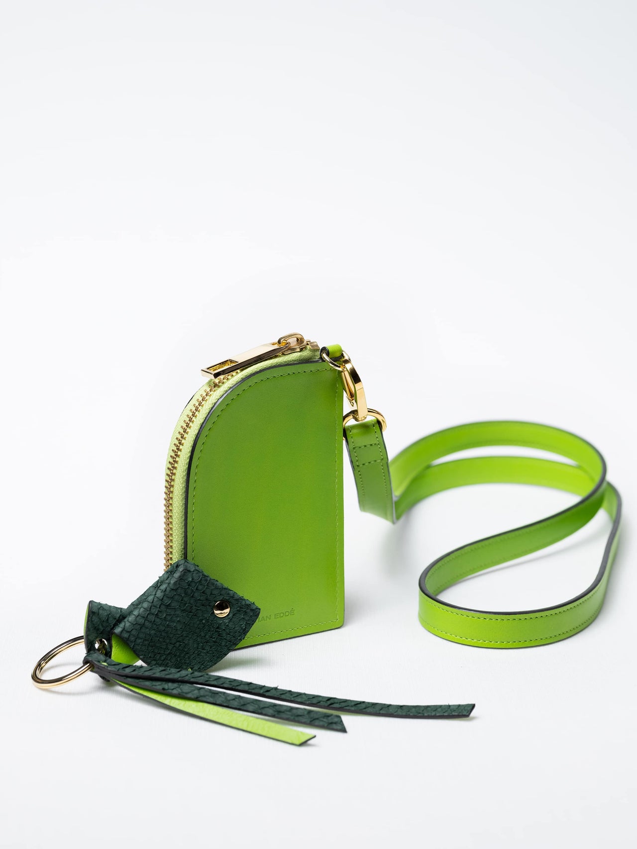 Salma zipper wallet on strap in kelp green nappa leather with gold zipper and a fish leather key charm, sustainable luxury by Kristian Eddé