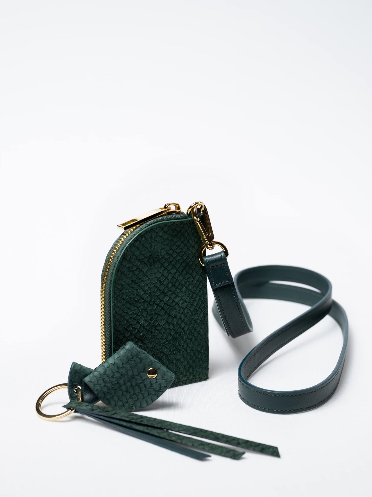 Salma zipper wallet on strap in kelp green fish leather with gold zipper and key charm – sustainable luxury by Kristian Eddé