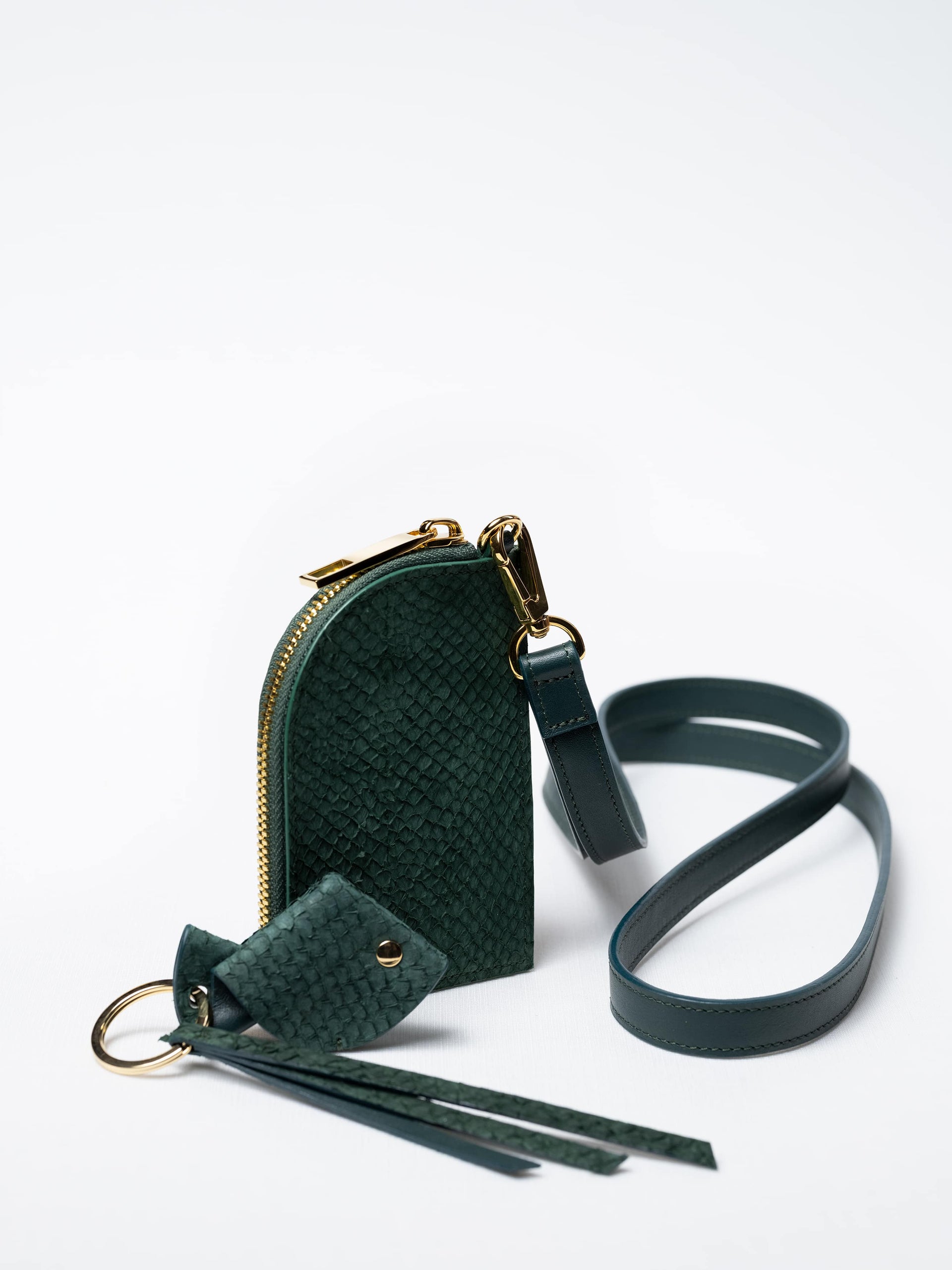 Salma zipper wallet on strap in kelp green fish leather with gold zipper and key charm – sustainable luxury by Kristian Eddé