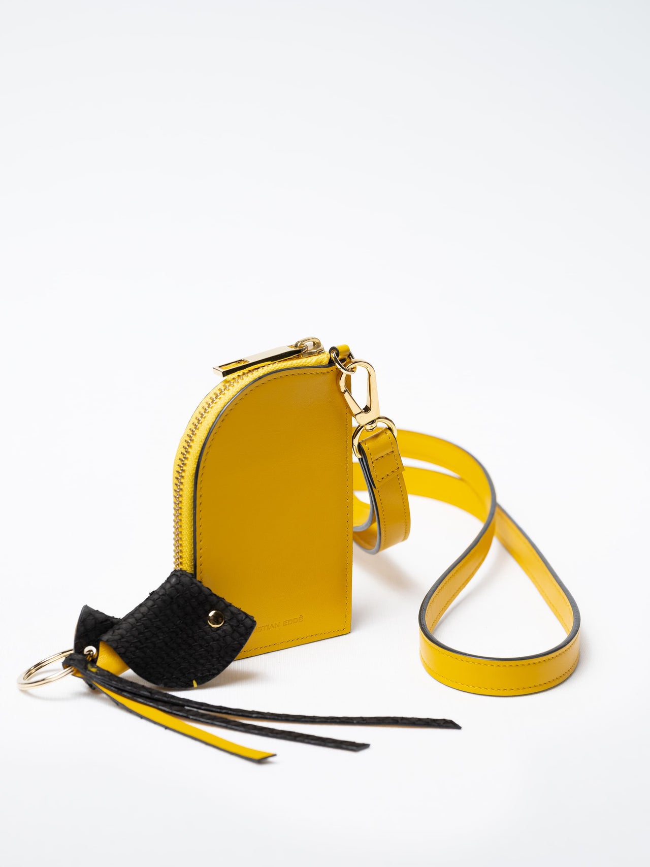 Salma zipper wallet on strap in yellow nappa leather with gold zipper and a fish leather key charm, sustainable luxury by Kristian Eddé