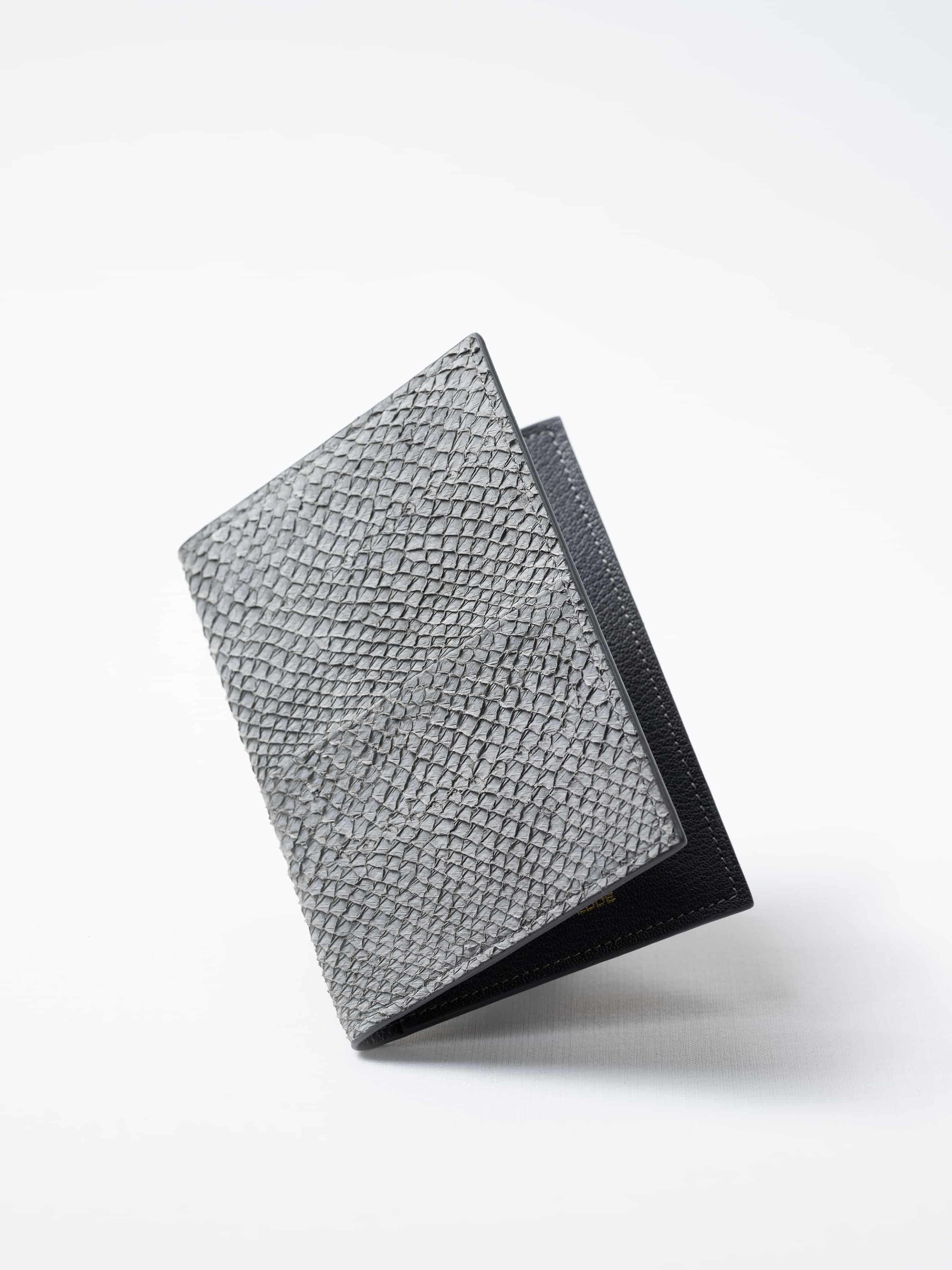 Vega luxury travel wallet in gray salmon leather, closed view highlighting the textured fish leather exterior, handcrafted  in Sweden by Kristian Eddé