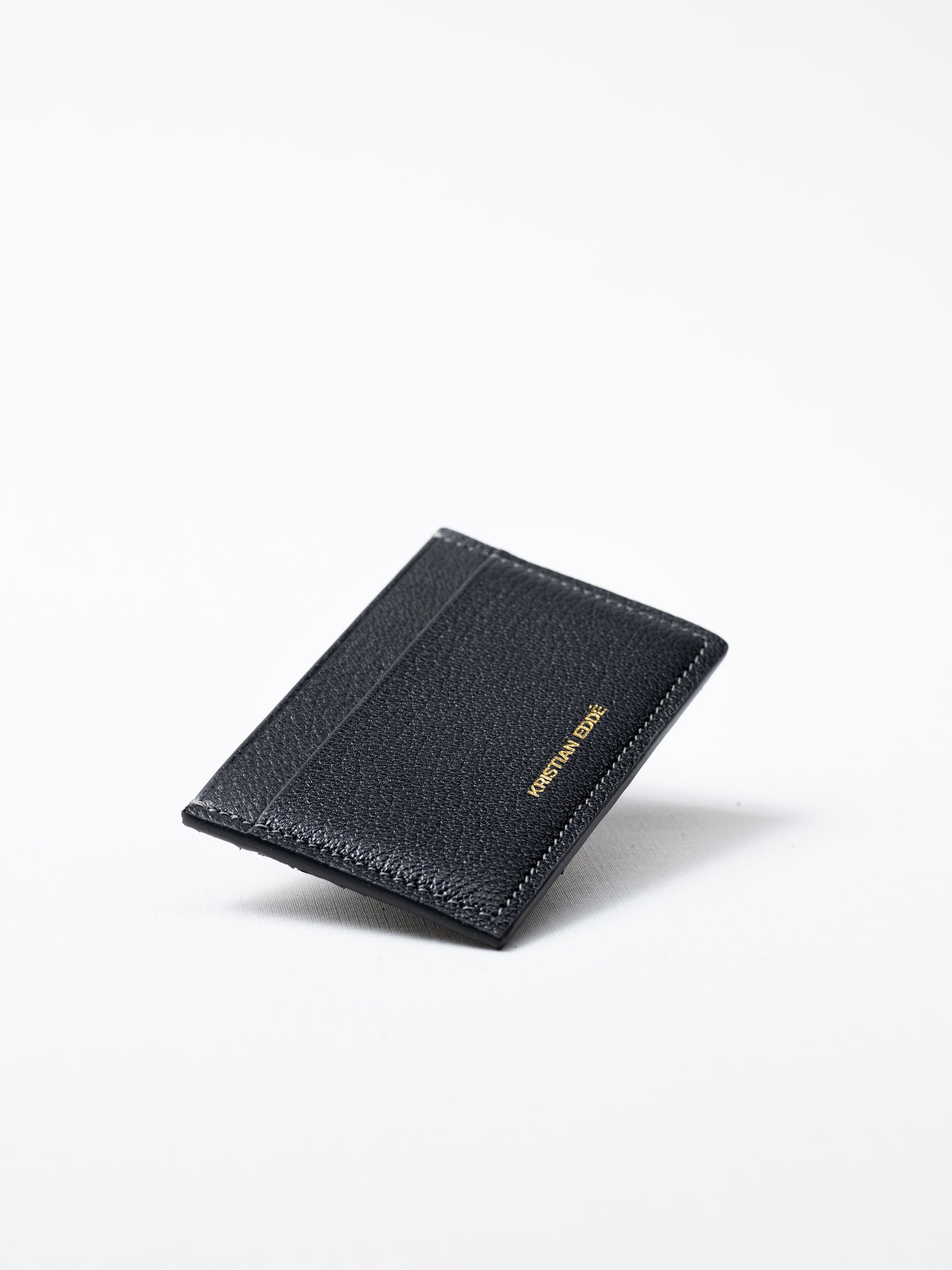 Bothnia gray card holder made of salmon leather, back view of gold logo on white background