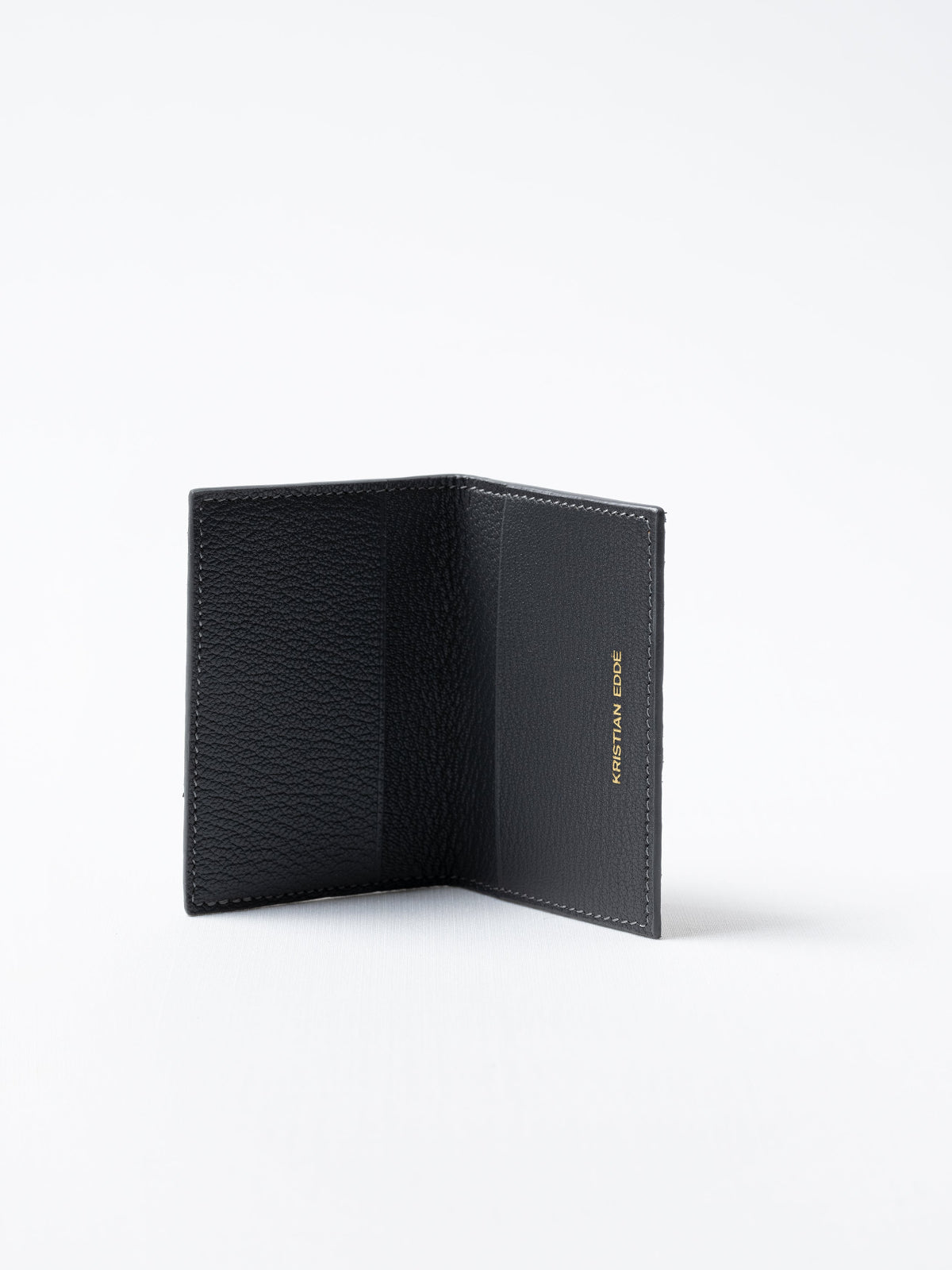 Barents cardholder made of  gray salmon leather with logo in gold, open view showing card slots
