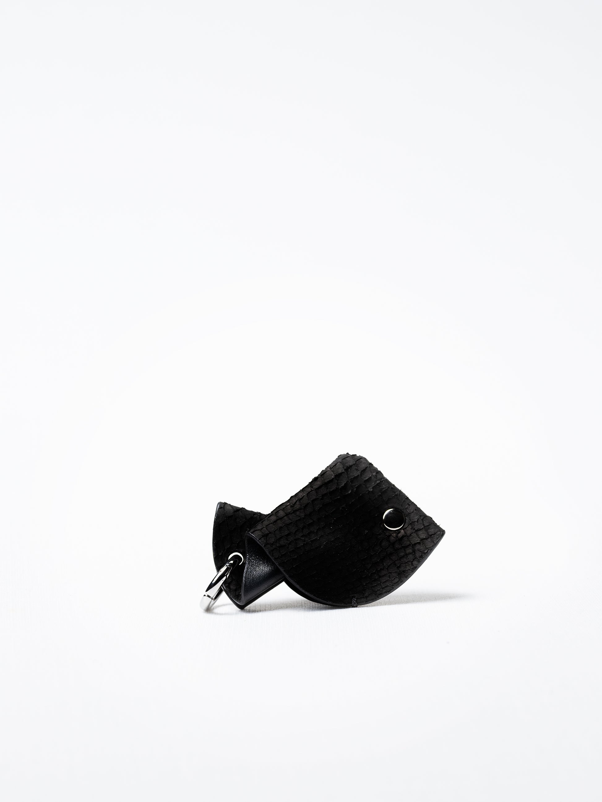Fish key charm in black salmon leather, silver-plated hardware shown against white background