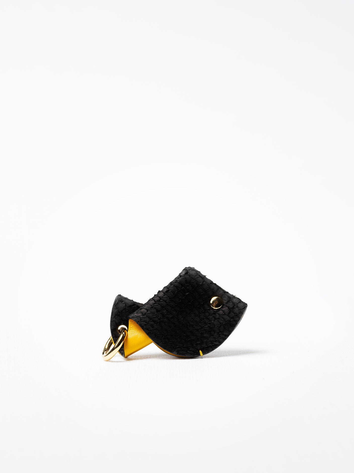 Fish key charm in black and yellow salmon leather, side view showing profile and depth