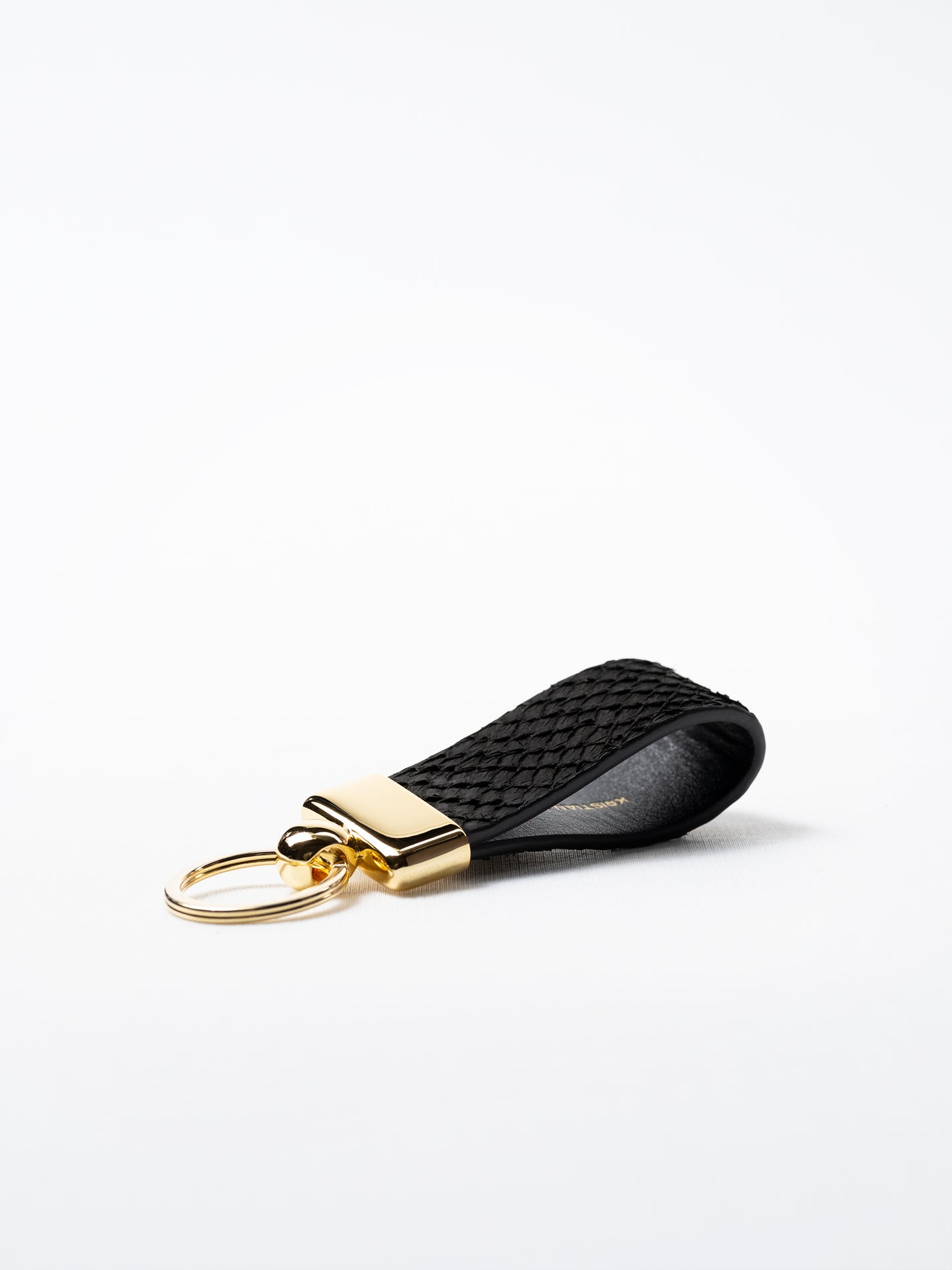 Black salmon leather key ring, side view showing natural grain and gold hardware